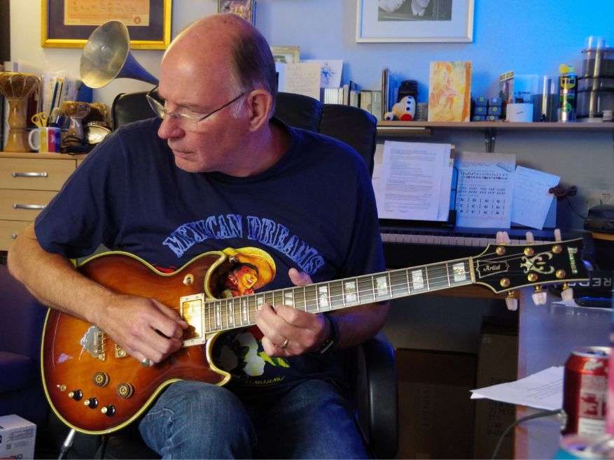 Ian Housley playing a Les Paul guitar in front of an organ