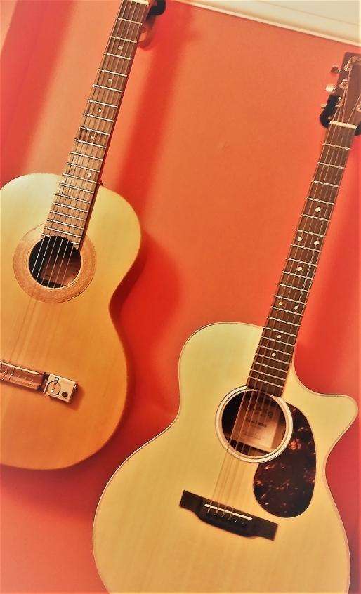 Guitars hanging against a red wall
