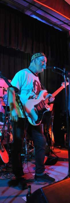 ZiPP singing on stage holding a guitar