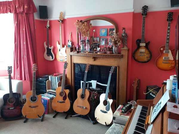 Guitars displayed hanging on a wall and on stands