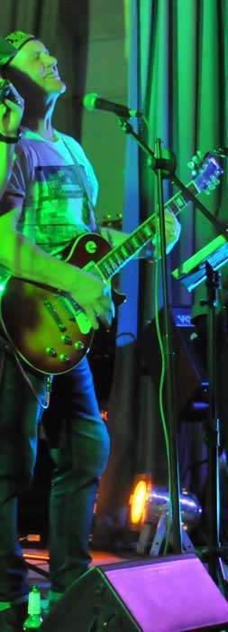 STEViE ZiPP performing on stage with a guitar