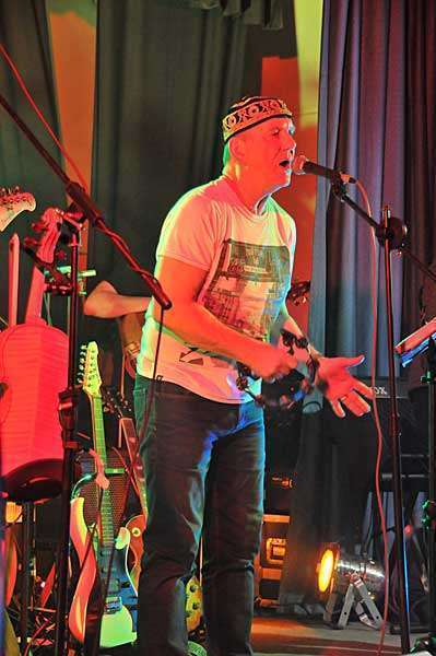 STEViE ZiPP singing on stage whilst playing a Tambourine