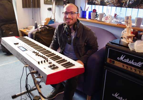 Tom-O-Martin sitting behind a keyboard in a recording studio