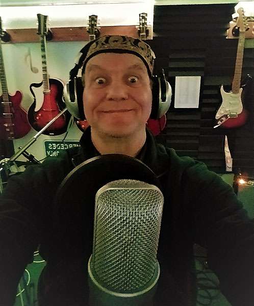 STEViE ZiPP wearing a fez and smiling into the camera whilst in the studio