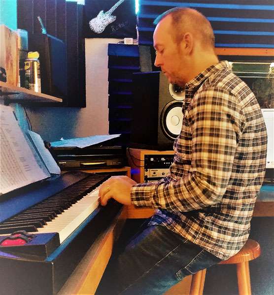 Jacob playing an organ in the studio